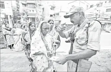  ??  ?? File photo shows a security personnel checking the identity card of a woman as she stands in a queue with others to cast their vote at a polling station during the fifth phase of general election in Howrah, on the outskirts of Kolkata, India. — Reuters photo
