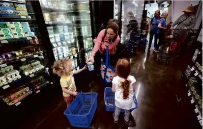  ?? ?? Leigh Arakelian shopped with her children Luka, 2, and Liv, 3, at the market, which opened after a decade-long capital campaign that raised $2 million and got 2,100 members on board.