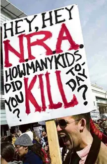  ?? Jose Luis Magana/Associated Press ?? Cartaz de participan­te da marcha na capital dos EUA indaga: ‘oi, oi, NRA, quantas crianças você matou hoje?’