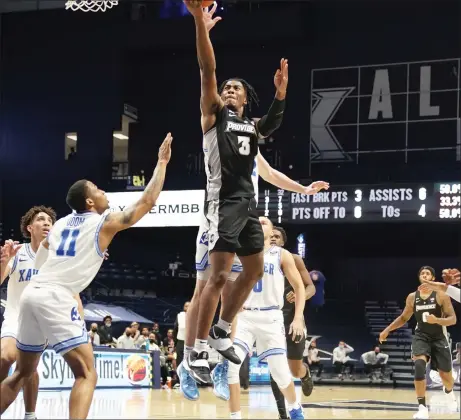  ?? Photos courtesy of Xavier University Athletics ?? Providence College junior guard David Duke (3, above) scored 30 points and helped PC take a seven-point lead late against Xavier, but the Musketeers ended the Big East game on an 8-0 run to secure a 74-73 home win. Jimmy Nichols (5, below) had seven points and five assists in the loss.