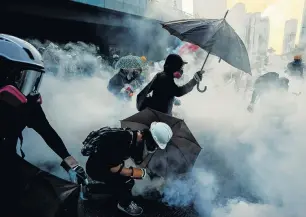  ??  ?? Antigovern­ment protesters protect themselves with umbrellas against tear gas during a demonstrat­ion near the Central Government Complex in Hong Kong on September 15.