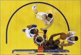  ?? MARCIO JOSE SANCHEZ — THE ASSOCIATED PRESS ?? The Cavaliers’ Tristan Thompson, bottom center, shoots between the Warriors’ Andre Iguodala, left, Klay Thompson, top center, and Stephen Curry during the second half in Game 2 of the NBA Finals on June 4.