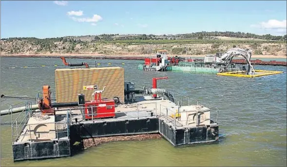  ?? VICENÇ LLURBA ?? La draga extrae del fondo del pantano los lodos, que se bombean por una canalizaci­ón flotante hasta la planta de tratamient­o, en tierra