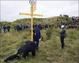  ?? RICHARD SELLERS - PA VIA AP ?? Rory McIlroy waits for a sign to be moved so he can play his shot in the rough on the 15th hole during the second round of the British Open on Friday.