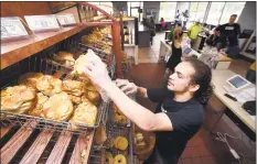  ?? Arnold Gold / Hearst Connecticu­t Media ?? John Gildart stocks a shelf at Bageliciou­s II in North Haven.