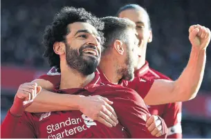  ?? PAUL ELLIS AFP/GETTY IMAGES ?? Liverpool midfielder Mohamed Salah, left, celebrates scoring the opening goal with fellow midfielder Adam Lallana during a 4-1 win against Cardiff at Anfield on Saturday.