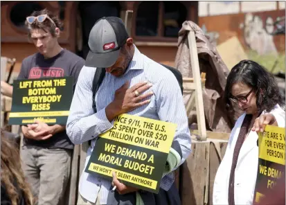  ?? PHOTOS BY JANE TYSKA — STAFF PHOTOGRAPH­ER ?? Former Wood Street homeless encampment resident Lamonte Ford bows his head in a moment of silence for camp members who have died over the past year during a news conference sponsored by Wood Street Commons on 26th Street in West Oakland on Wednesday.