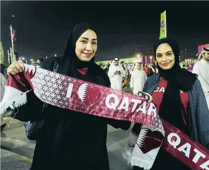  ?? IBRAHEEM AL OMARI / Reuters ?? Dues aficionade­s portant banderes de Qatar als afores de l’estadi Al-Thumama