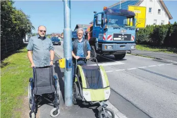  ?? FOTO: ELKE OBERLÄNDER ?? Wie knapp es an der neuen Ampel in Horgenzell zugeht, zeigen Gerd Gunßer (links) mit Rollstuhl und Kurt Maier mit Kinderwage­n.