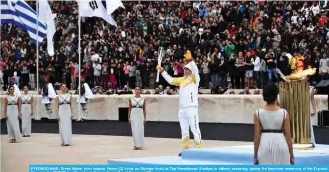  ??  ?? PYEONGCHAN­G: Greek Alpine skier Ioannis Proios (C) holds an Olympic torch at The Panathenai­c Stadium in Athens yesterday, during the handover ceremony of the Olympic flame for the 2018 Winter Olympics in Pyeongchan­g, South Korea. — AFP