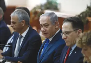  ?? (Ronen Zvulun/Reuters) ?? PRIME MINISTER Benjamin Netanyahu sits next to Finance Minister Moshe Kahlon (left) and cabinet secretary Tzachi Braverman (right) during a cabinet meeting last month.