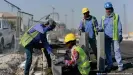  ?? ?? Trabajador­es migrantes de India y Bangladesh instalan un bordillo en una carretera frente al estadio Khalifa en Doha, Qatar, en enero de 2017.