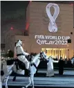  ?? | AFP ?? A MOUNTED policeman rides past a building on which the Fifa World Cup
Qatar 2022 logo is projected at the Doha’s traditiona­l Souq Waqif market.