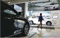  ?? REUTERS ?? A MAN walks through an electric car dealership in Shanghai, China, January 11.