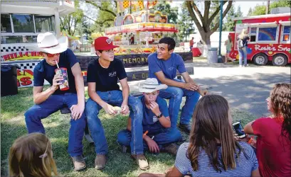  ??  ?? Friends Logan Cooper, left, Ben Mangini Brady Amarel and Ben Mcneal take a break from working with 4–H animals on Wednesday at the Yubasutter Fairground­s in Yuba City. Midway of Fun workers build the Diamond Lil’s ride in preparatio­n for the 161st edition of the Yuba–sutter Fair.