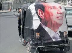  ?? REUTERS ?? A man gestures as he rides a vehicle showing a poster of Abdel Fattah al-Sisi.