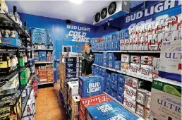  ??  ?? Braxtun Brown, an OnCue clerk, arranges beer Oct. 1 inside the Beer Cave, where customers can select chilled brew at their business located at the northwest corner of the E 15th Street and Interstate 35 intersecti­on in Edmond.