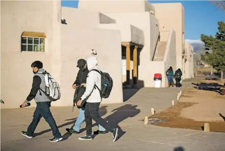  ?? PHOTOS BY LUIS SÁNCHEZ SATURNO/THE NEW MEXICAN ?? Students walk on campus last week at Santa Fe Indian School, one of nine Indigenous schools in the country selected to receive a new schoolyard through a federal pilot program that aims to shift Native American boarding schools away from their traumatic history and create spaces that embrace Indigenous traditions. The school hopes to install new walkways, outdoor classrooms and natural catchment systems.