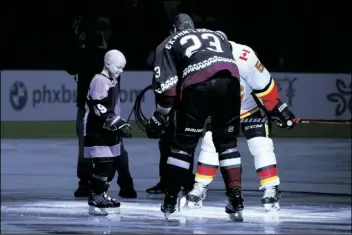  ?? ROSS D. FRANKLIN/AP ?? LEIGHTON ACCARDO (LEFT) WHO IS BATTLING CANCER, drops the puck in front of Arizona Coyotes’ Oliver Ekman-Larsson (23) and Calgary Flames’ Mark Giordano (5) during an NHL Fights Cancer puck drop ceremony prior to an NHL hockey game in Glendale, in this Saturday, Nov. 16, 2019, photo.