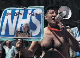  ?? PHOTO: REUTERS ?? Sense of ownership . . . Demonstrat­ors hold placards during a march in support of the National Health Service, in central London, late last month.
