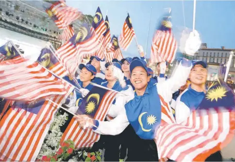  ?? — Photo by Muhammad Rais Sanusi ?? Youngsters waving the Jalur Gemilang during a segment of the programme.