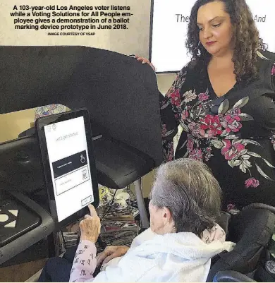  ?? IMAGE COURTESY OF VSAP ?? A 103-year-old Los Angeles voter listens while a Voting Solutions for All People employee gives a demonstrat­ion of a ballot marking device prototype in June 2018.