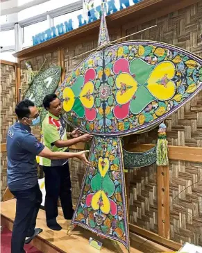  ??  ?? House of kite: Museum supervisor Ismat Salleh (left) and Azmi displaying a wau merak at the museum in Pasir Gudang.