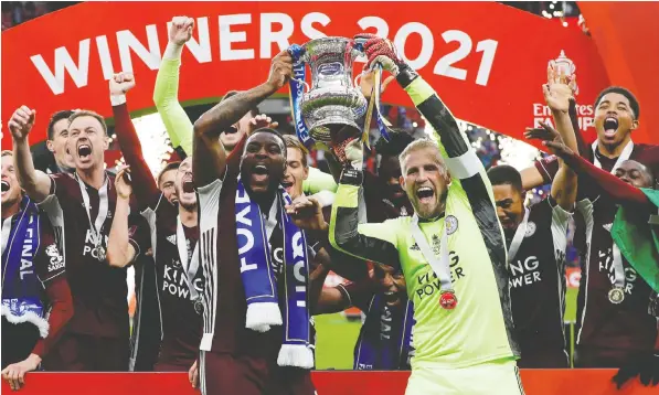  ?? KIRSTY WIGGLESWOR­TH/POOL VIA REUTERS ?? Leicester City's Kasper Schmeichel and Wes Morgan celebrate winning their team's first FA Cup on Saturday.