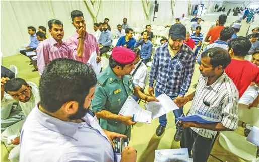  ?? File photo ?? An officer assists amnesty-seekers at Al Aweer immigratio­n centre tent in Dubai. The tent will be open to amnesty-seekers until October 31. —