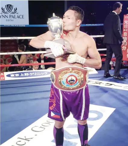  ?? CONTRIBUTE­D FOTO / CARLOS COSTA ?? KISS. Donnie Nietes kisses the trophy awarded to him after beating Japanese star Kazuto Ioka in their World Boxing Organizati­on super flyweight title fight in Macau on New Year’s eve.