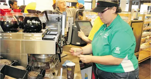  ?? JOCELYN TURNER / POSTMEDIA NEWS FILES ?? Same-store volume at Tim Hortons outlets in Canada slid 0.2 per cent, prompting analyst concerns that the beloved brand might be getting oversatura­ted on its home turf. Starbucks and McDonald’s have eaten into its coffee trade.