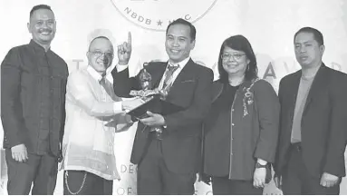  ?? PHOTO FROM PHILIPPINE FOOD ILLUSTRATE­D FB POST ?? Edgie Mercado Polistico (center) receives the 36th National Book Awards from the National Book Developmen­t Board (NBDB) and the Manila Critics Club (MCC) during the 2017 awarding ceremony at the National Museum of the Philippine­s in Manila. Polistico,...