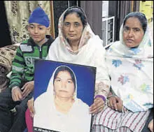  ?? HT PHOTO ?? Family of Amrik Kaur, who died in 2014, with her photograph at their home in Amarkot, Tarn Taran, on Monday.