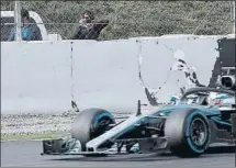  ?? FOTO: EFE ?? Alonso, al fondo de la imagen, sacando fotos al Mercedes