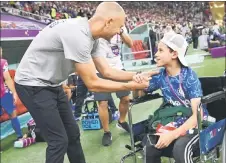 ?? — AFP photo ?? Berhalter greets a USA supporter ahead of the Group B match against England at the Al-Bayt Stadium in Al Khor, north of Doha.