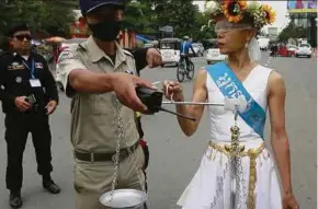  ?? EPA PIC ?? A police officer speaking to Cambodian-American human rights activist Theary Chan Seng, dressed as Lady Justice, at the Municipal Court in Phnom Penh, Cambodia, earlier this month.