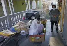  ?? RICK BOWMER
AP PHOTO/ ?? Evelyn Maysonet looks at the food delivery from the Weber-Morgan Health Department Tuesday in Ogden, Utah. Maysonet has been isolating with her husband and son in their Ogden home since all three tested positive for COVID-19 over a week ago. None of them have been able to leave home to buy groceries so Maysonet said they were thrilled to receive the health department’s delivery.