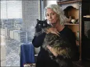  ?? DAN SULLIVAN /TAMPA BAY ?? Christine Lee holds her long-haired house cat, Calli, in her condominiu­m in downtown Tampa on Thursday. In a lawsuit, a contractor alleges that he was attacked by a bobcat while working in the condo.