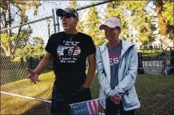  ??  ?? Trump supporters Todd Blee and wife Heidi Whipple pass the fenced-off Capitol building just blocks from their home in Sacramento on Sunday.