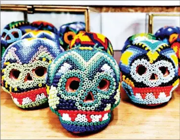  ?? NEVIN MARTELL/THE WASHINGTON POST ?? Small clay skulls decorated with tiny beads, an artistic specialty of the country’s Huichol people, are on sale at Ciudadela, one of Mexico City’s finest arts markets.