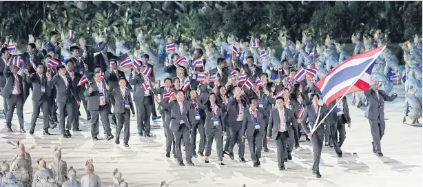  ?? PHOTO: AP ?? KINGDOM CONTINGENT: Volleyball star Pleumjit Thinkaow carries the national flag as the Thai team marches in the Gelora Bung Karno Stadium during the opening ceremony for the 18th Asian Games in Jakarta last night.