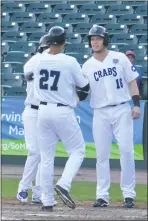  ?? PHOTO BY BERT HINDMAN ?? Blue Crabs center fielder Cory Vaughn is congratula­ted by teammates L.J. Hoes and Michael Snyder after delivering a three-run home run in the bottom of the fifth inning of a 4-1 victory over Bridgeport in Game 1 of a doublehead­er at Regency Furniture...