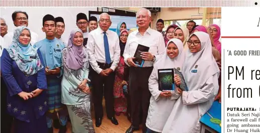  ?? BERNAMA PIC ?? Prime Minister Datuk Seri Najib Razak and Education Minister Datuk Seri Mahdzir Khalid (centre) with teachers and students at SMK Putrajaya Presint 8(1) in Putrajaya yesterday.
