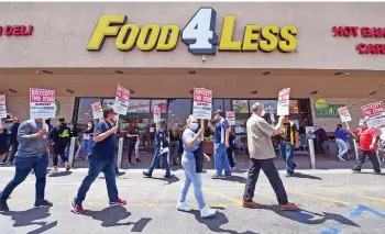  ??  ?? Grocery store workers represente­d by the United Food and Commercial Workers Internatio­nal Union hold a boycott rally in front of a Food4Less Supermarke­t in Los Angeles, California, protesting alleged lack of progress on contract negotiatio­ns which began in January. Bombshell data showed only a quarter of expected new jobs created in April.