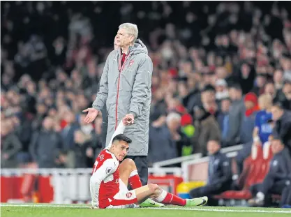  ??  ?? Arsenal manager Arsene Wenger helps Alexis Sanchez to his feet during a recent Premier League match.