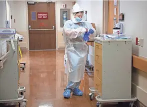  ?? LIZ DUFOUR/CINCINNATI ENQUIRER ?? A nurse dons full personal protection equipment prior to going into a patient’s room on the COVID-19 floor at Trihealth Good Samaritan Hospital in April 2020. Due to the new coronaviru­s pandemic, safety protocols have changed to protect both the patients and the workers.