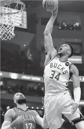  ?? Morry Gash/associated Press ?? Scoring 50 points in only 30 minutes? That feat was a slam dunk for the Bucks’ Giannis Antetokoun­mpo on Sunday, as the Pelicans’ Jonas Valanciuna­s found out.