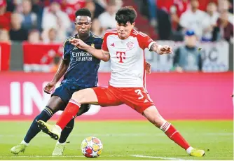  ?? AP-Yonhap ?? Bayern’s Kim Min-jae, right, challenges for the ball with Real Madrid’s Vinicius Junior during the UEFA Champions League semifinal first-leg football match at the Allianz Arena in Munich, Germany, Tuesday.