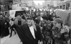  ?? AP PHOTO/ANMAR KHALIL ?? Mourners carry the flag-draped coffins of two fighters of the Popular Mobilizati­on Forces who were killed during the US attack on against militants in Iraq, during their funeral procession at the Imam Ali shrine in Najaf, Iraq, on Saturday.