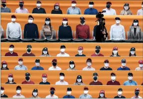  ?? LEE JIN-MAN — THE ASSOCIATED PRESS ?? A TV cameraman walks through spectators seating, which is covered with pictures of fans, before the start of a game between the Hanwha Eagles and SK Wyverns in Incheon, South Korea on May 5.